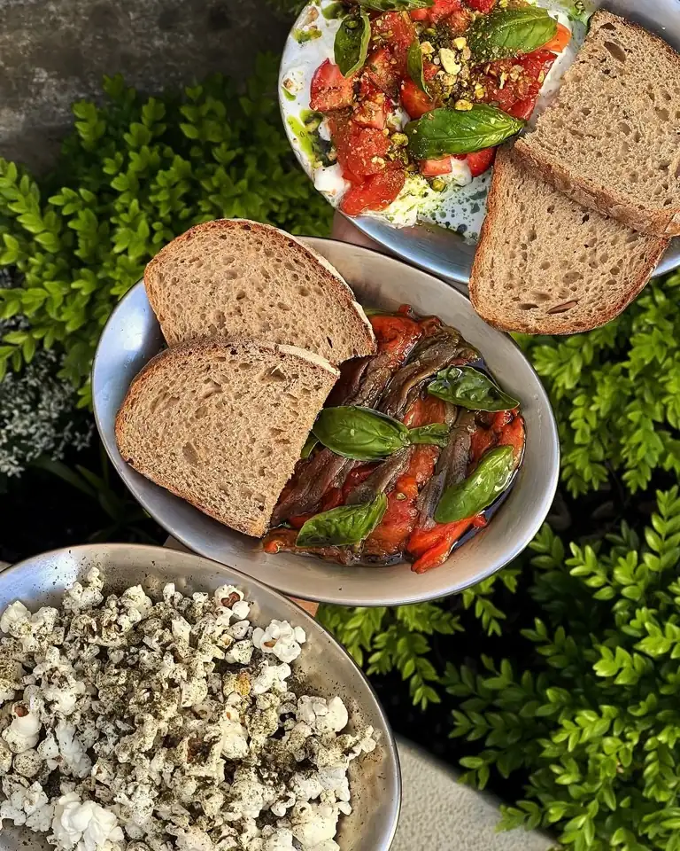Open toasts and nori-togarashi popcorn served over the terrace greenery